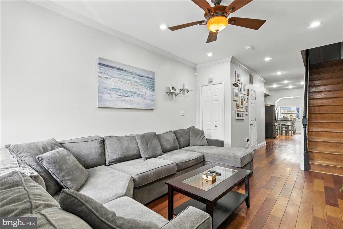 a living room with furniture and a wooden floor