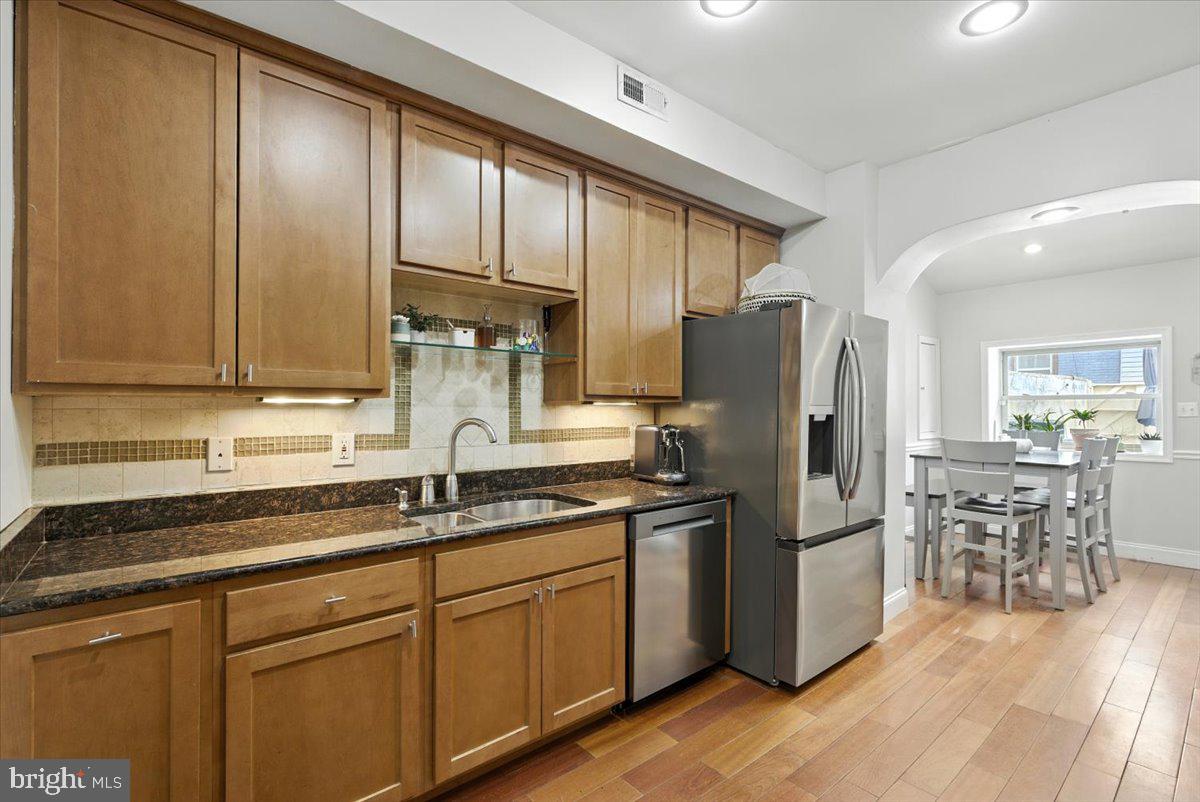 1711 South Hanover Street Baltimore, MD 21230 - Photo 11 of 31 a kitchen with granite countertop stainless steel appliances a refrigerator a sink a stove and cabinets