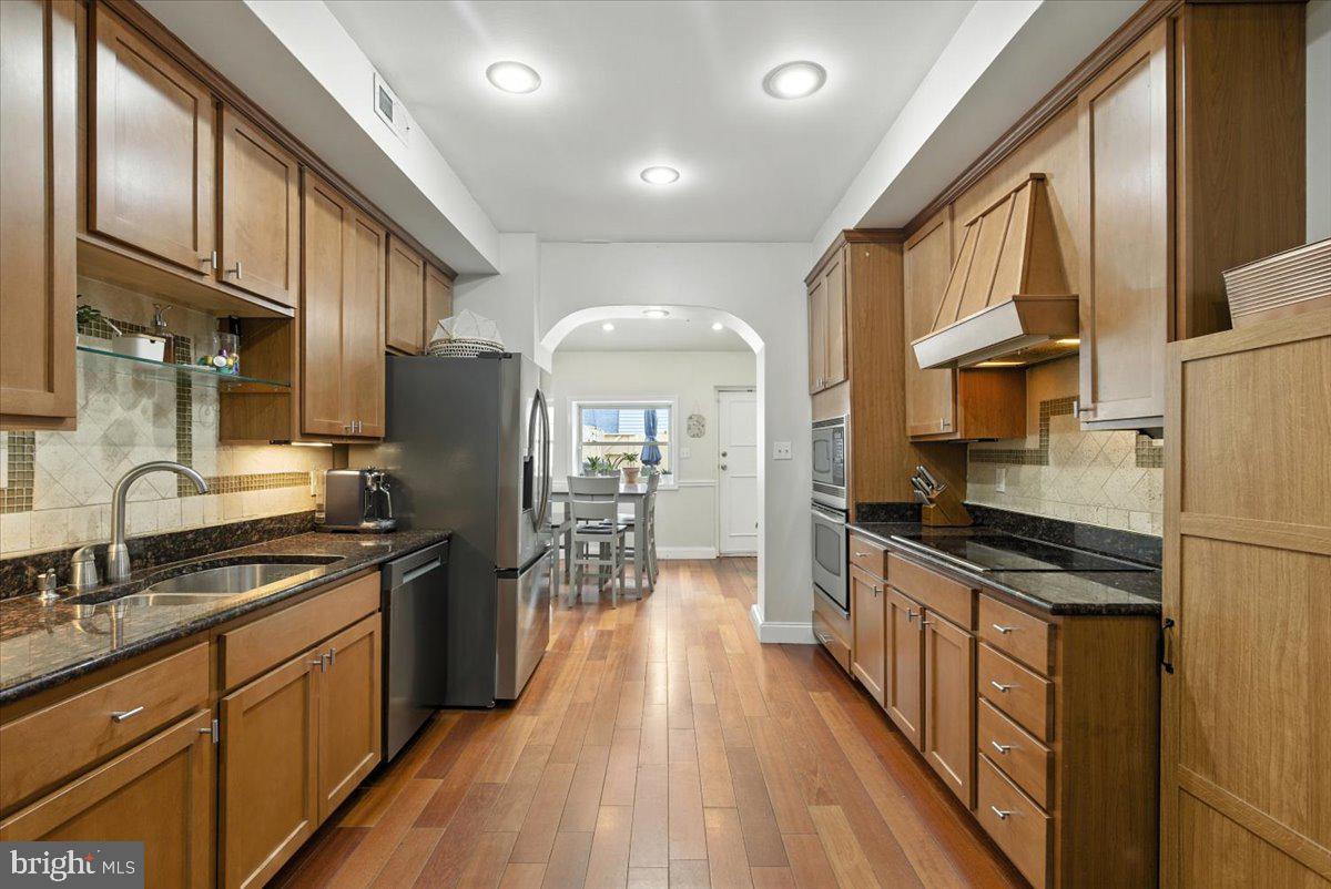 1711 South Hanover Street Baltimore, MD 21230 - Photo 9 of 31 a kitchen with stainless steel appliances a stove top oven a sink a refrigerator cabinets and dining table