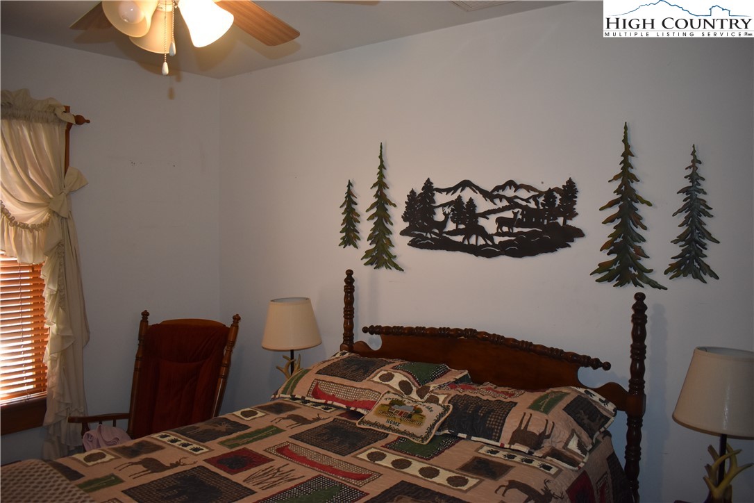 748 River Hills Road Lansing, NC 28643 - Photo 29 of 47 a bed sitting in a bedroom next to a lamp next to a window
