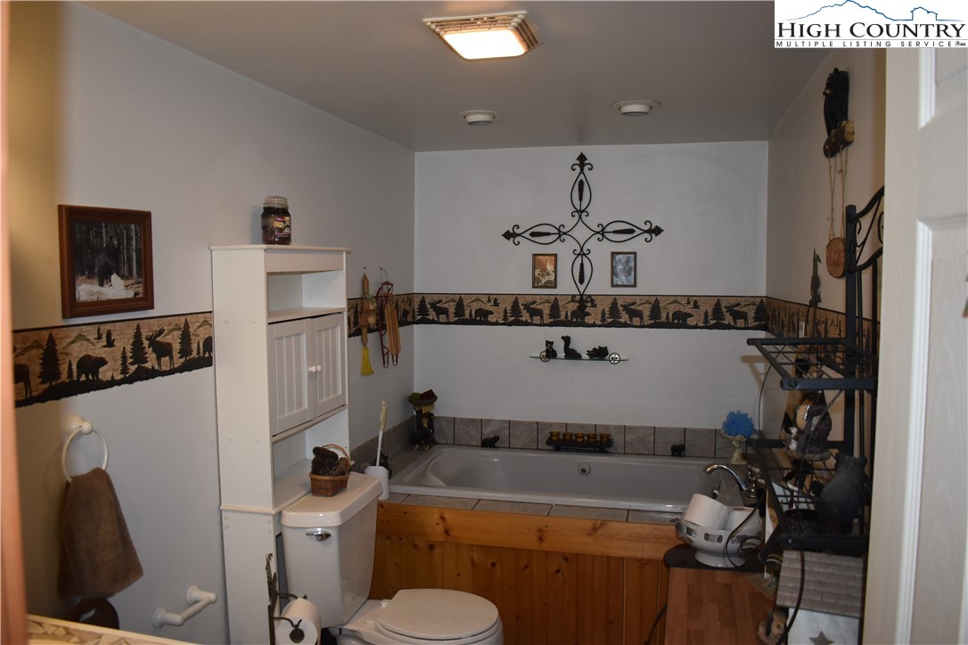 748 River Hills Road Lansing, NC 28643 - Photo 35 of 47 a bathroom with a sink a toilet and a mirror