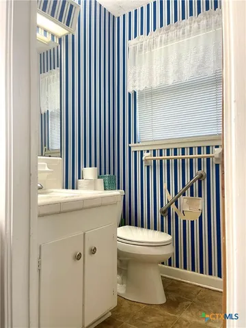 a bathroom with a sink and mirror with toilet