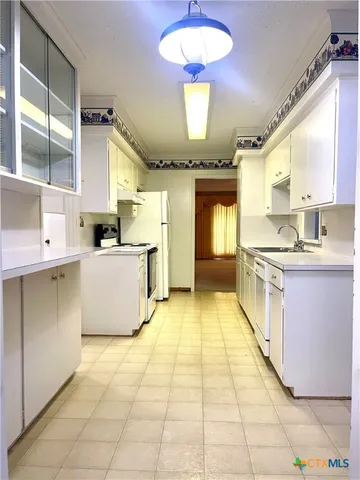 a large kitchen with a large counter top appliances and cabinets