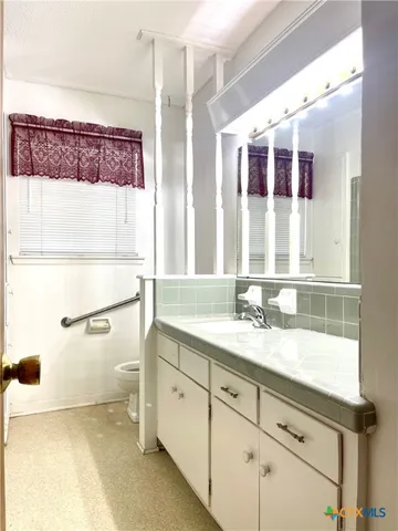 a bathroom with a granite countertop sink mirror and