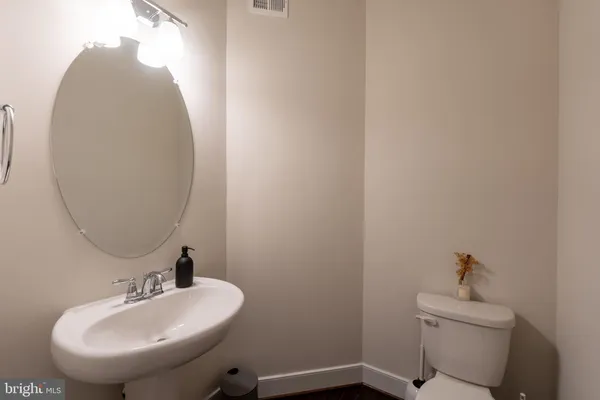 a bathroom with a sink and mirror with toilet