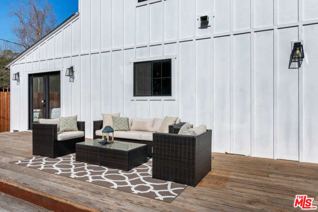 3628 Grayburn Road Pasadena, CA 91107 - Photo 23 of 25 a living room with couches bookshelf and a window with wooden floor