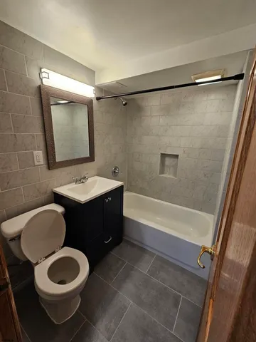 a bathroom with a sink vanity mirror and toilet