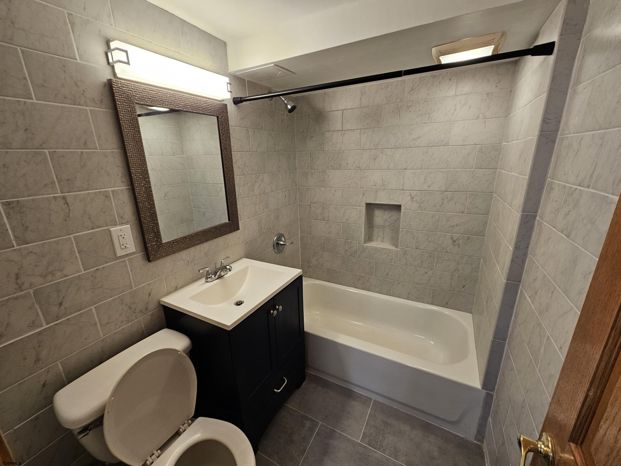 7 South Laclede Place, Unit 1 Atlantic City, NJ 08401 - Photo 15 of 21 a bathroom with a sink vanity mirror and toilet