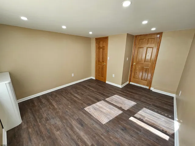 a view of a hallway to a room with wooden floor and stairs