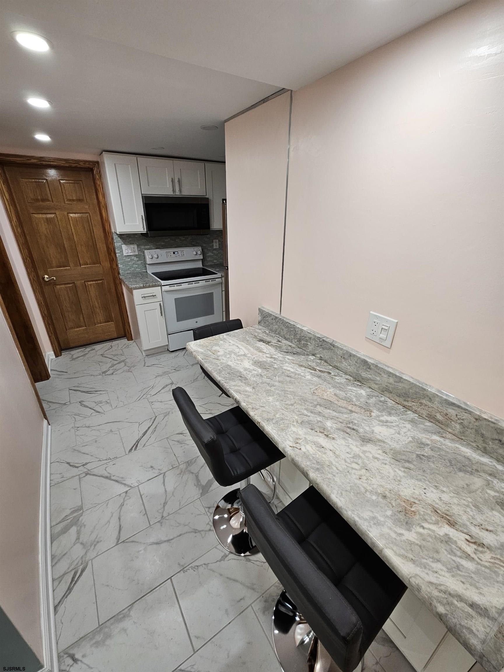 7 South Laclede Place, Unit 1 Atlantic City, NJ 08401 - Photo 6 of 21 a kitchen with granite countertop a sink stove and refrigerator