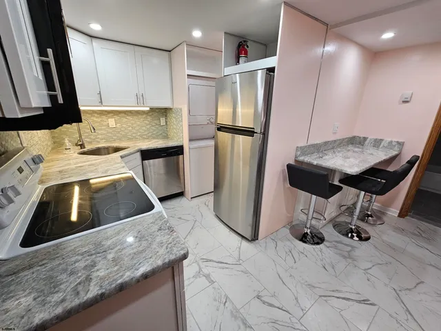 a kitchen with a sink a refrigerator and a stove top oven