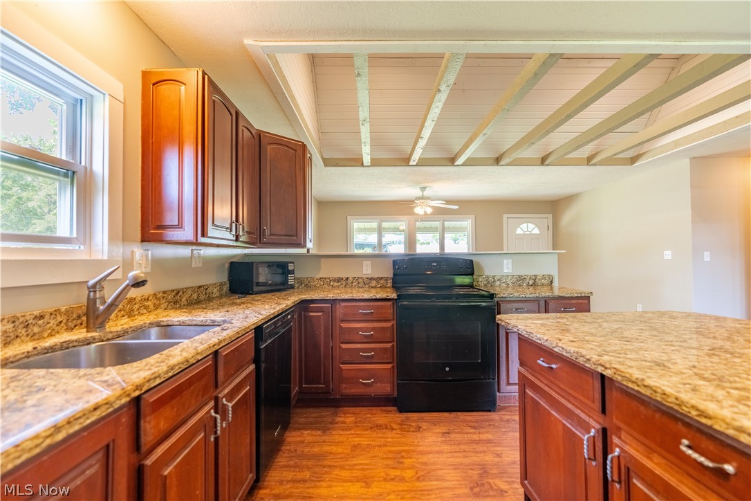 1889 Ronald Road Akron, OH 44312 - Photo 21 of 36 Kitchen with ceiling fan, light stone counters, black appliances, and wood-type flooring