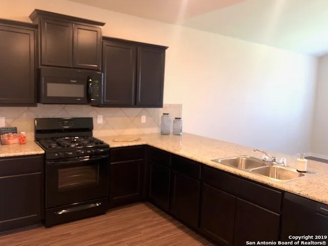 a view of a room with wooden floor and a window