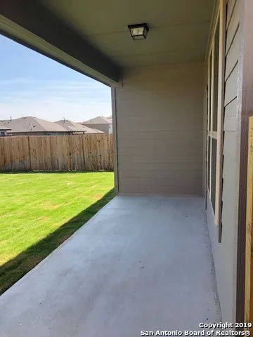 a view of backyard with wooden fence