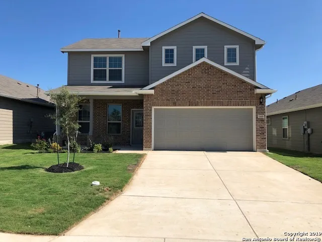 a front view of a house with a yard and trees