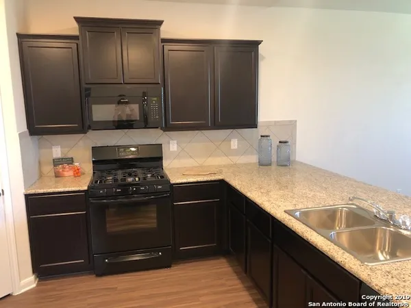 a kitchen with granite countertop a refrigerator and a sink