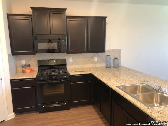 a kitchen with granite countertop a refrigerator and a sink