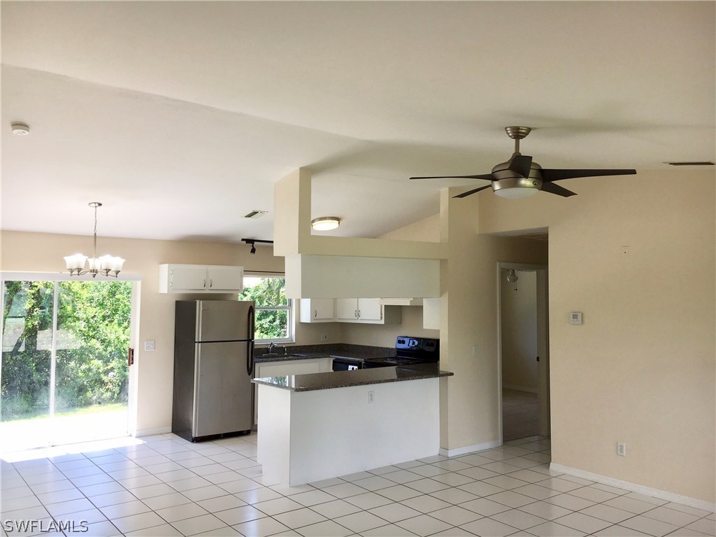18536 Sebring Road Fort Myers, FL 33967 - Photo 2 of 11 a kitchen with a refrigerator and a stove top oven