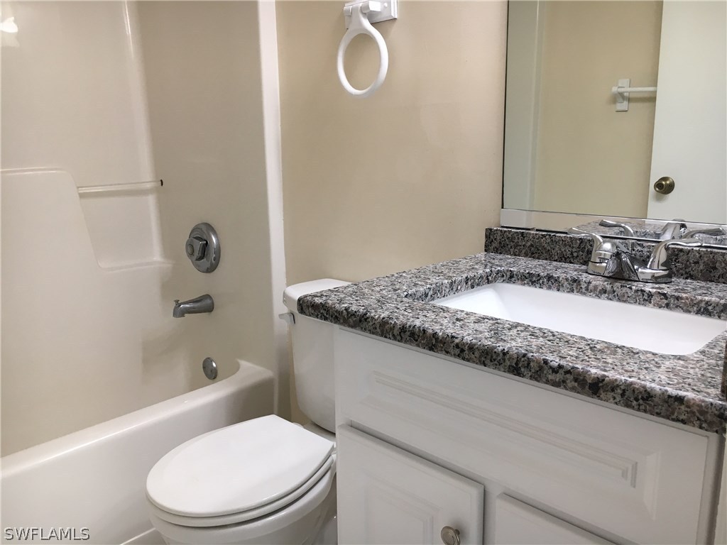 18536 Sebring Road Fort Myers, FL 33967 - Photo 7 of 11 a bathroom with a granite countertop sink toilet and shower