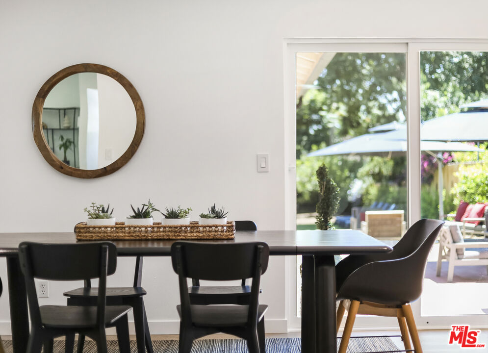 1364 East Woodbury Road Pasadena, CA 91104 - Photo 16 of 50 a dining room with wooden floor a glass table and chairs