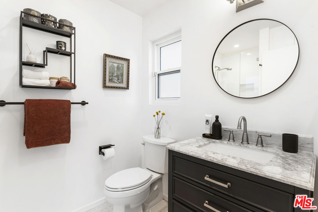 1364 East Woodbury Road Pasadena, CA 91104 - Photo 28 of 50 a bathroom with a granite countertop toilet sink and mirror