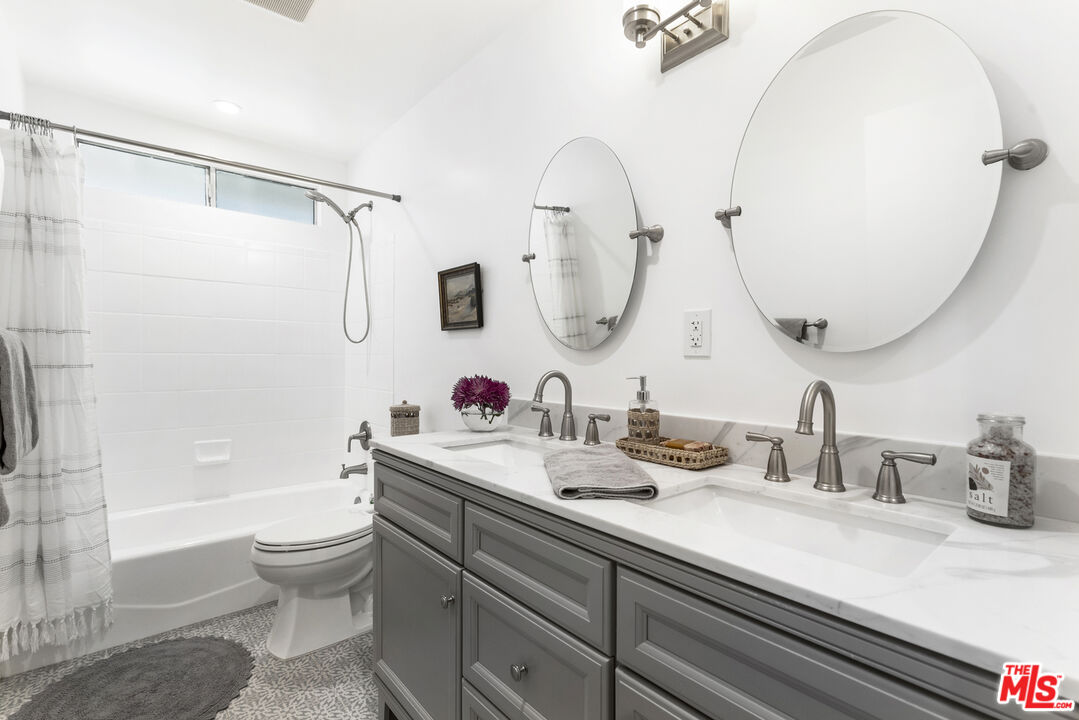 1364 East Woodbury Road Pasadena, CA 91104 - Photo 32 of 50 a bathroom with a granite countertop sink a toilet and a mirror