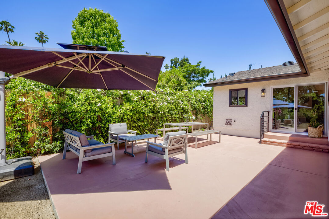1364 East Woodbury Road Pasadena, CA 91104 - Photo 38 of 50 a patio with a table and chairs under an umbrella