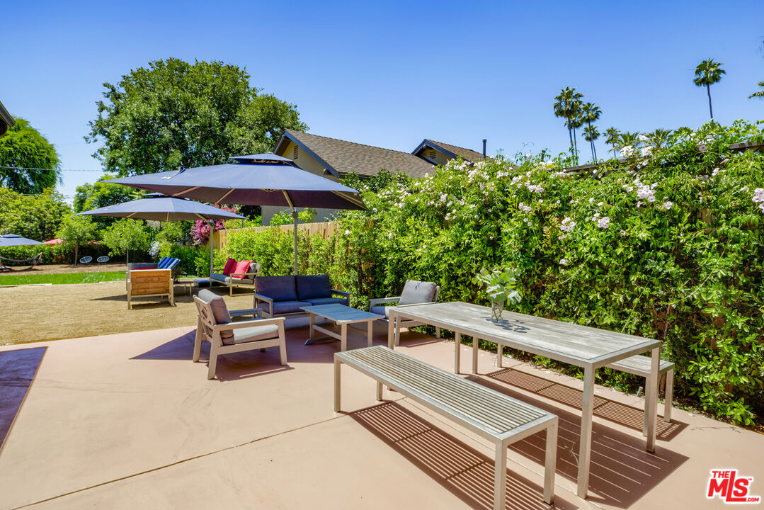 1364 East Woodbury Road Pasadena, CA 91104 - Photo 39 of 50 a view of a patio with a table and chairs under an umbrella