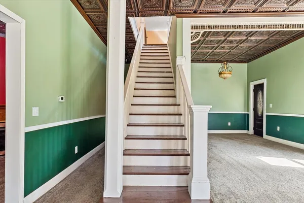 a view of a hallway with wooden floor and chandelier