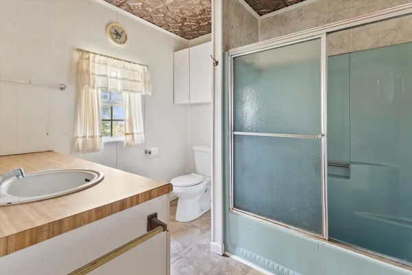 a view of an empty room with a fireplace and a window