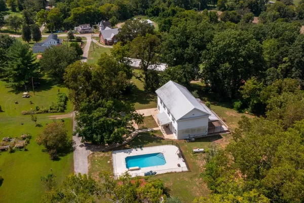 an aerial view of a house with swimming pool and garden view