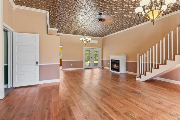 a view of a livingroom with a fireplace a chandelier and stairs