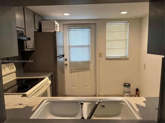 a room with a large window and stainless steel appliances