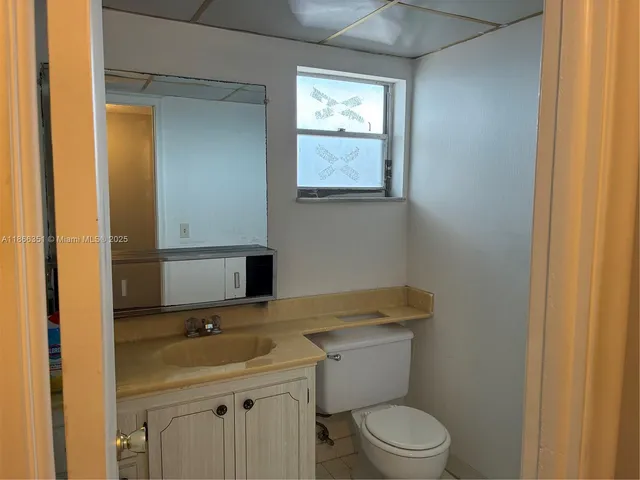 a bathroom with a toilet a sink and mirror