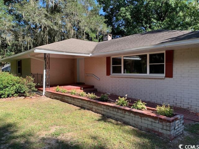48 Sandpiper Lane, Unit 48 SANDPIPER LANE Georgetown, SC 29440 - Photo 2 of 10 Ranch-style house with brick siding, a front yard, and a chimney