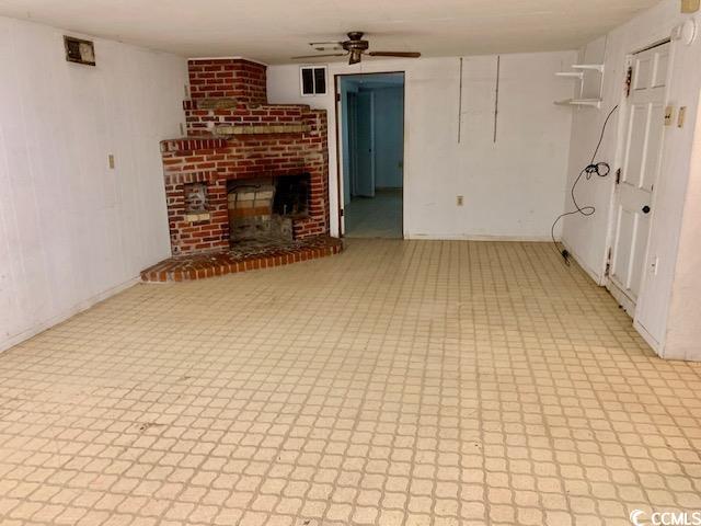 48 Sandpiper Lane, Unit 48 SANDPIPER LANE Georgetown, SC 29440 - Photo 7 of 10 Unfurnished recreation room featuring a ceiling fan and a decorative/non functional brick fireplace.