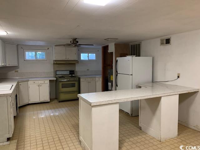 48 Sandpiper Lane, Unit 48 SANDPIPER LANE Georgetown, SC 29440 - Photo 8 of 10 Basement Kitchen featuring light countertops, white appliances, white cabinets, and light flooring