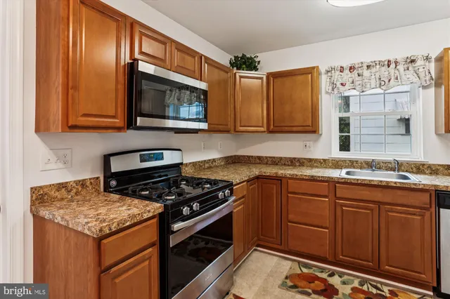 a kitchen with granite countertop cabinets stainless steel appliances and a counter space