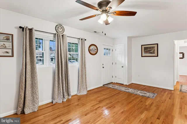a view of a big room with wooden floor and a ceiling fan