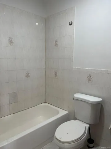 a white toilet and a bath tub