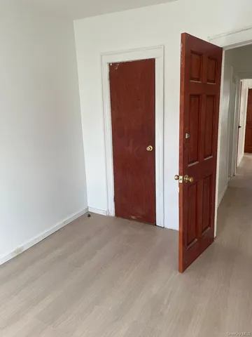 an empty room with closet and wooden floor