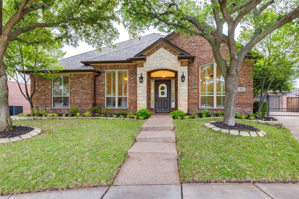 front view of a brick house with a yard