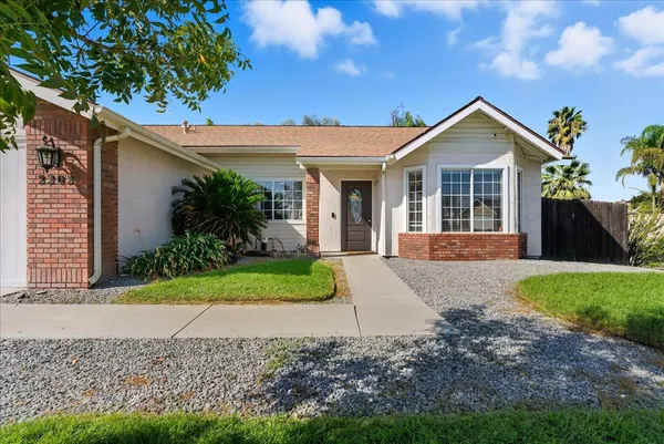 a front view of a house with a yard and potted plants