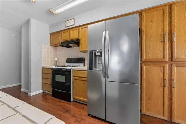 a kitchen with stainless steel appliances granite countertop a refrigerator and a sink