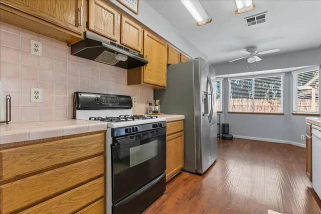 a kitchen with stainless steel appliances granite countertop a stove and a refrigerator