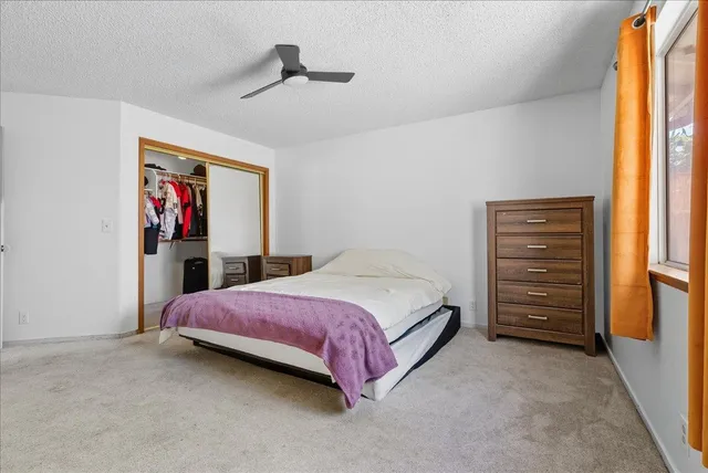 a bedroom with a bed a dresser and book shelf