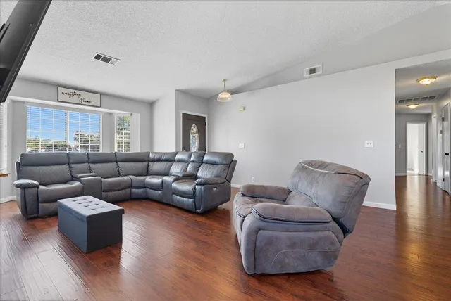 a living room with furniture and wooden floor