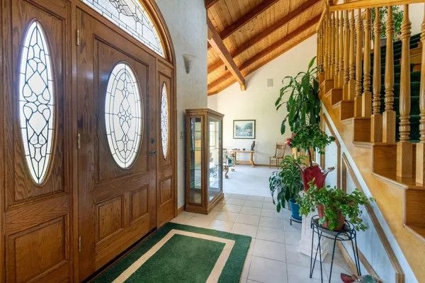 a view of a hallway with wooden floor and a clock on wall