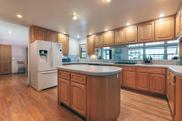 a kitchen with kitchen island granite countertop a sink stove and refrigerator