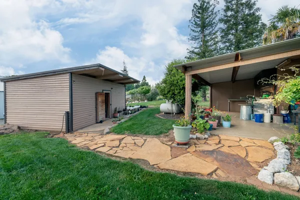 a view of a house with backyard and sitting area